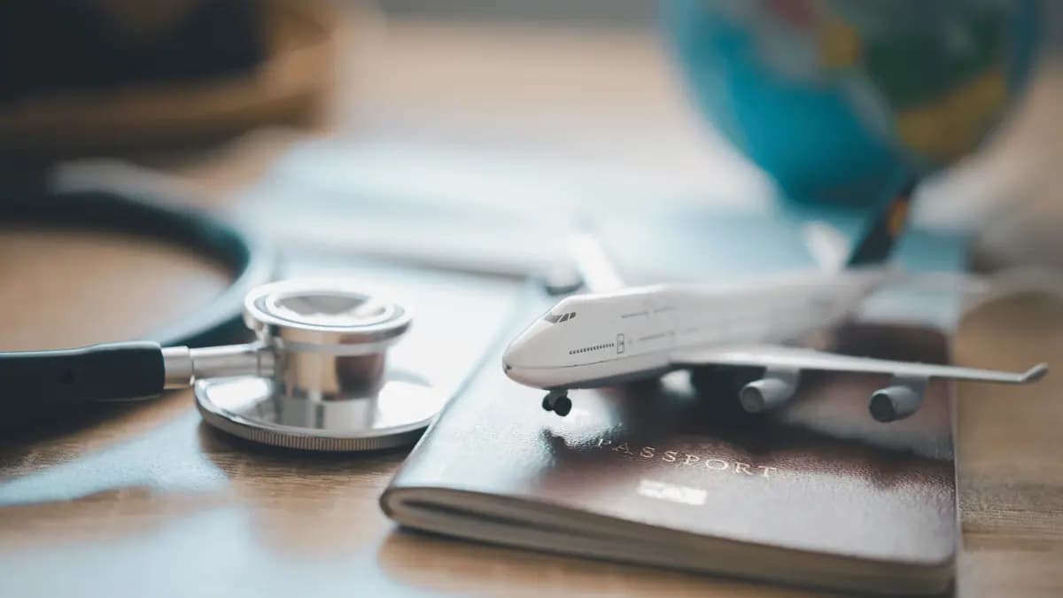 Toy aeroplane resting on a passport beside a globe