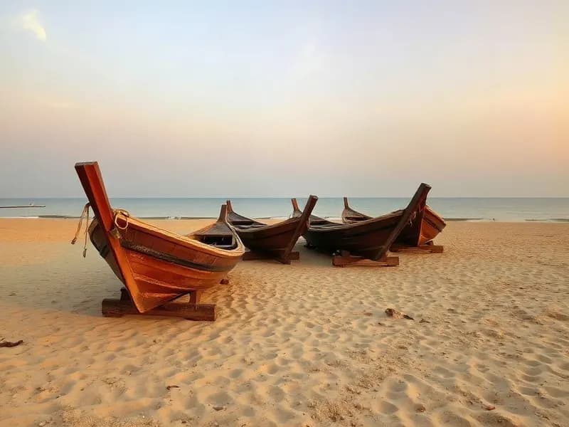 Illustrative view of wooden fishing boats on a sandy beach at sunrise, representing Chennai’s coast